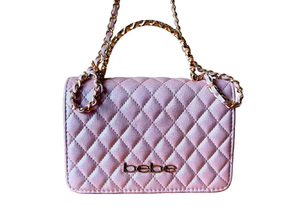 Pink quilted handbag with gold chain strap on a wooden surface