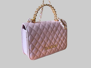 Quilted handbag with gold chain strap on a wooden surface
